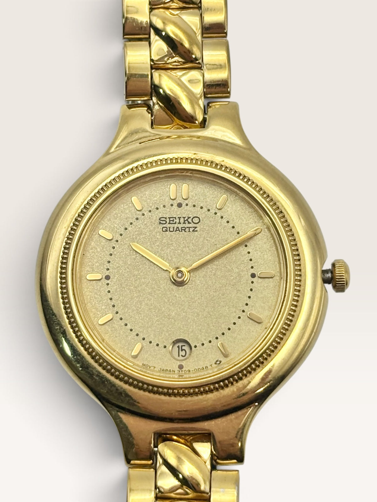 A vintage Seiko watch featuring a rounded gold-tone case