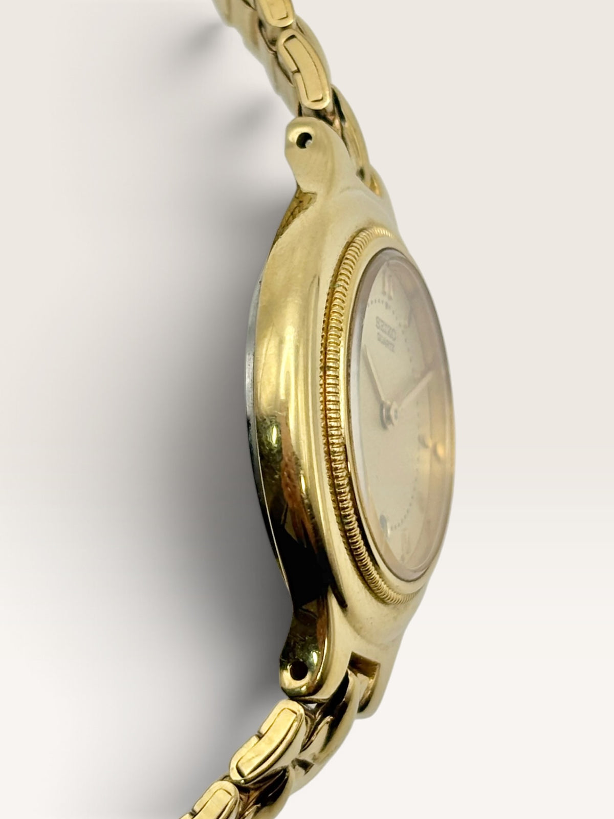 A vintage Seiko watch featuring a rounded gold-tone case