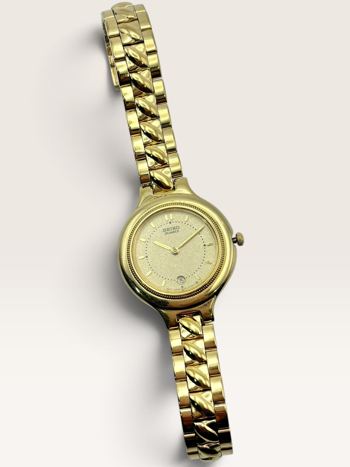 A vintage Seiko watch featuring a rounded gold-tone case