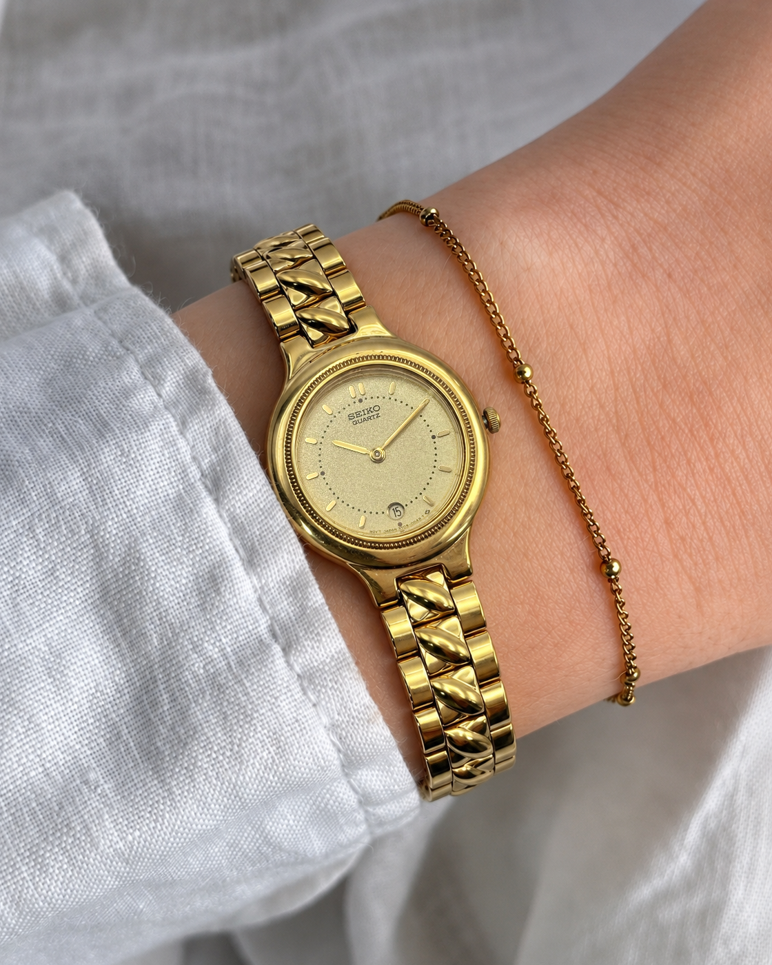 A vintage Seiko watch featuring a rounded gold-tone case